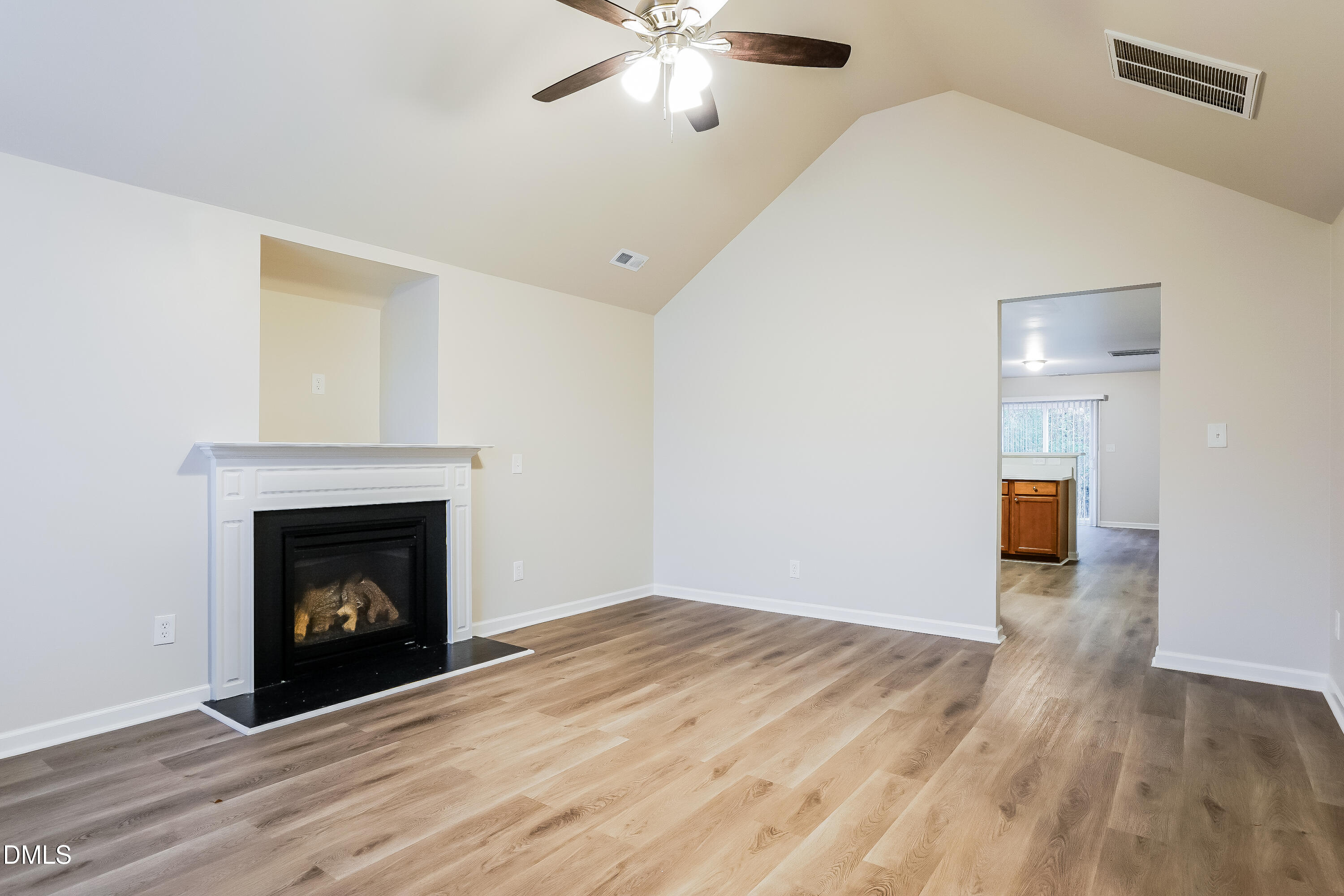 3405 Mogollon Court Raleigh, NC 27610 - Photo 3 of 16 a view of an empty room with wooden floor fireplace and a window