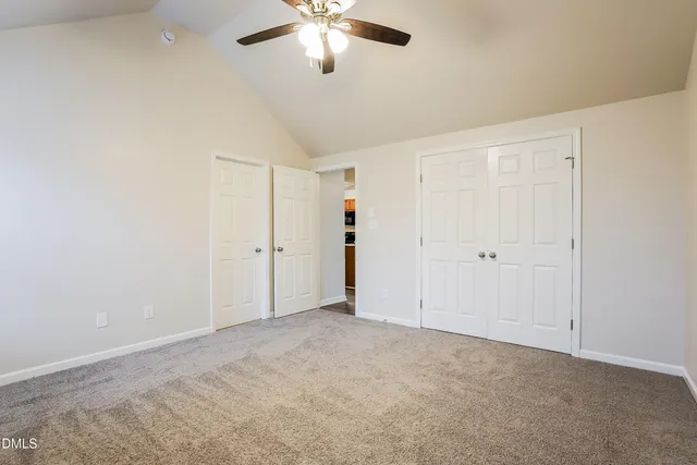 an empty room with chandelier fan