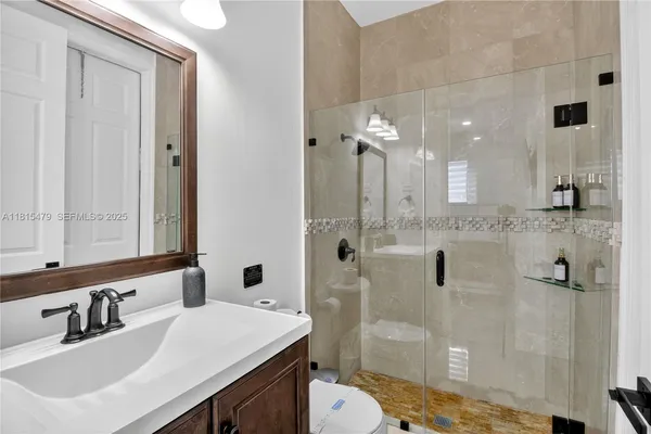 a bathroom with a sink toilet a mirror and shower