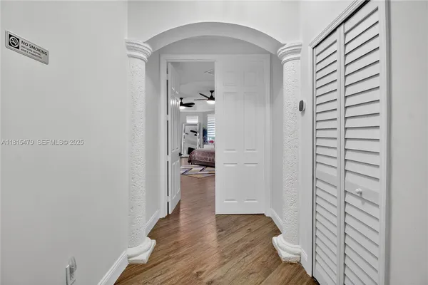 a view of a hallway with wooden floor and closet