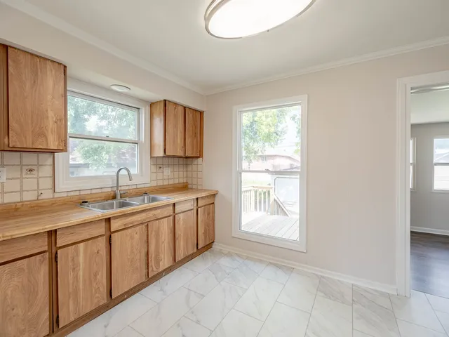 a kitchen with a sink window and cabinets