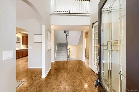 a view of a hallway with wooden floor and staircase