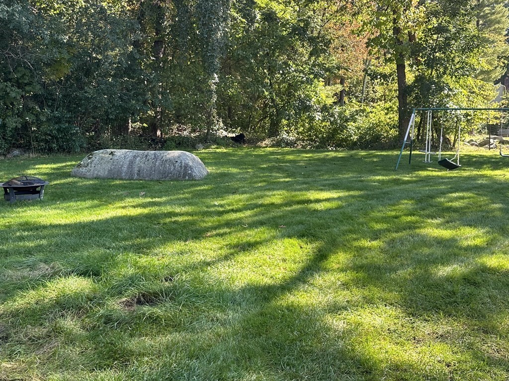2 Monticello Circle Billerica, MA 01821 - Photo 18 of 19 a backyard of a house with a fountain and large trees