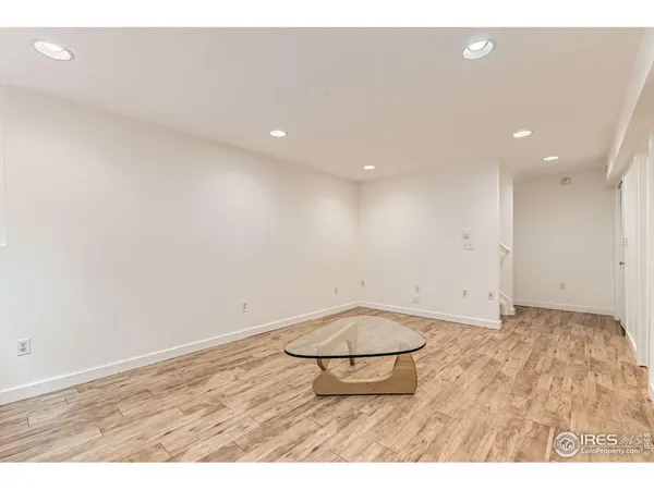 an empty room with wooden floor and glass door