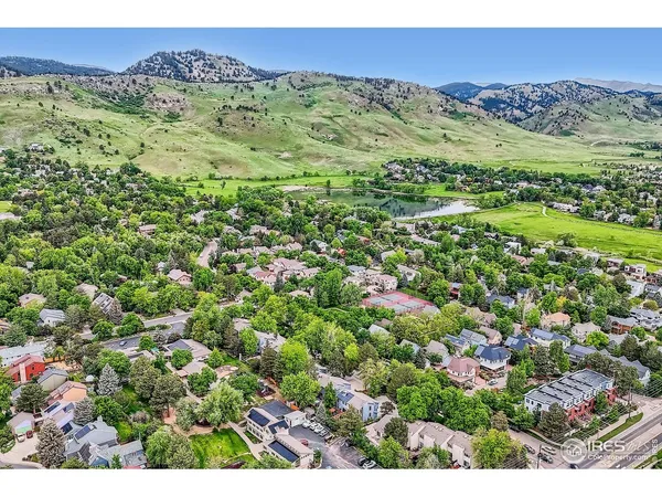 a view of a lush green field with mountains in the background