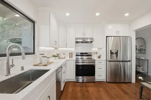 a kitchen with stainless steel appliances a stove a refrigerator and cabinets