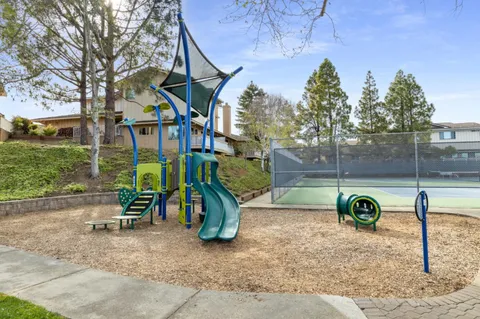 a view of a park with of a house in the background