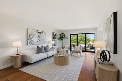 a living room with furniture a fireplace and a open kitchen view