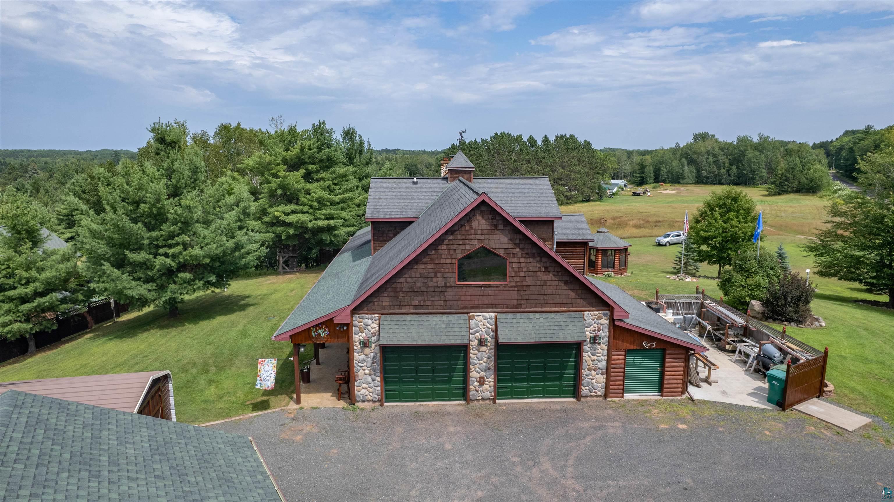11911 East Rowe Road Lake Nebagamon, WI 54849 - Photo 22 of 61 Rustic-style architecture featuring wood siding, stone accents, and green garage doors