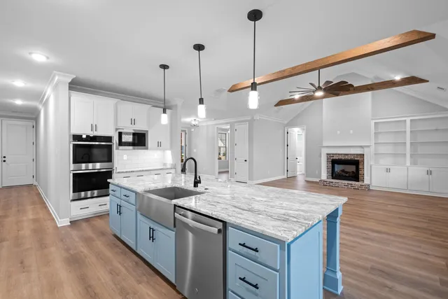 a kitchen with granite countertop a sink a counter top stainless steel appliances and cabinets