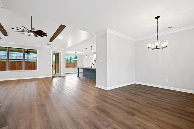 a view of empty room with wooden floor and window