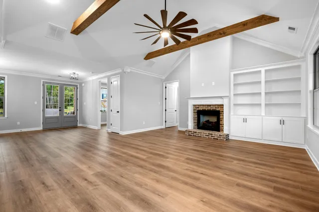 a view of an empty room with a window and a fireplace