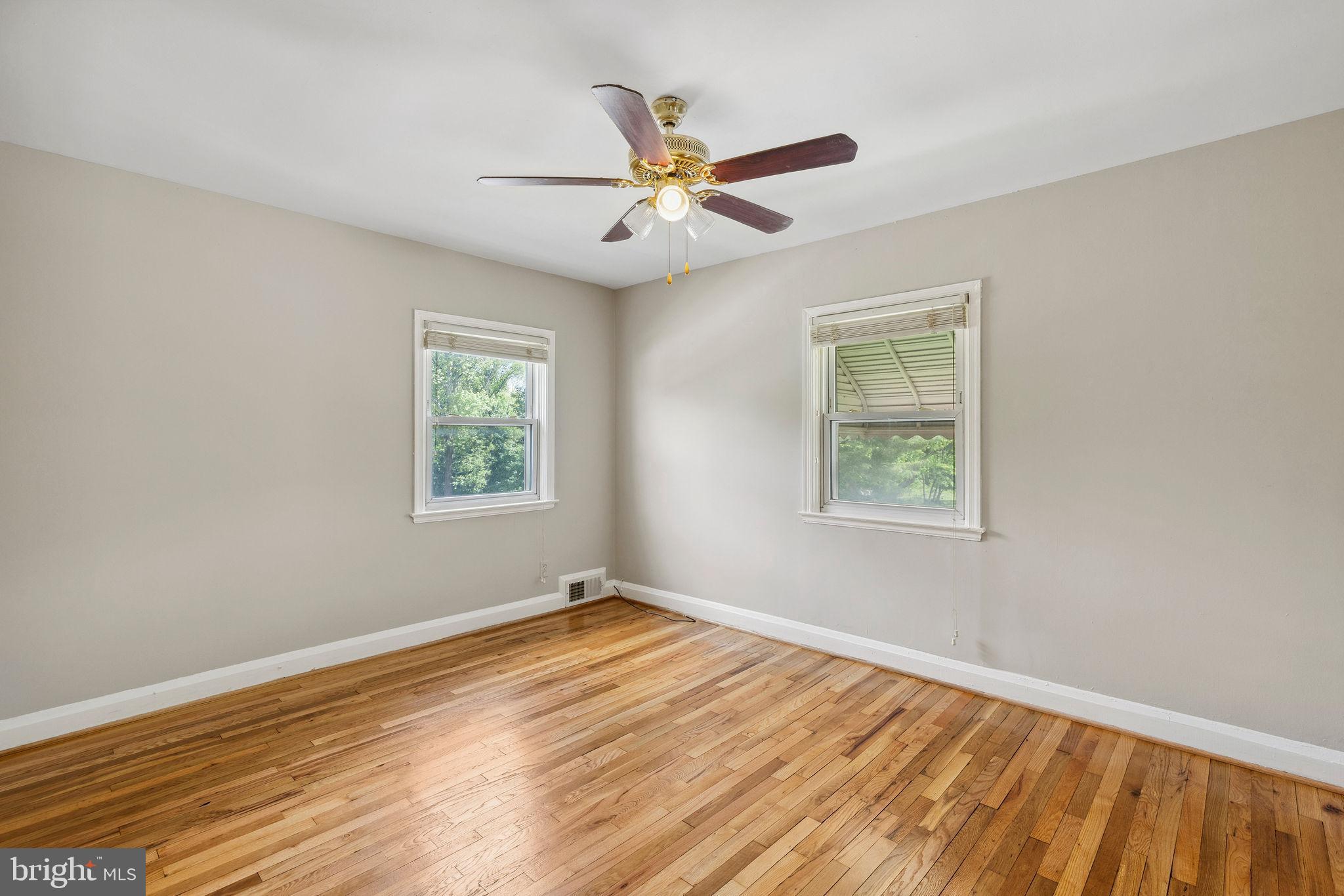 1581 Stonewood Road Baltimore, MD 21239 - Photo 13 of 21 an empty room with wooden floor windows and fan