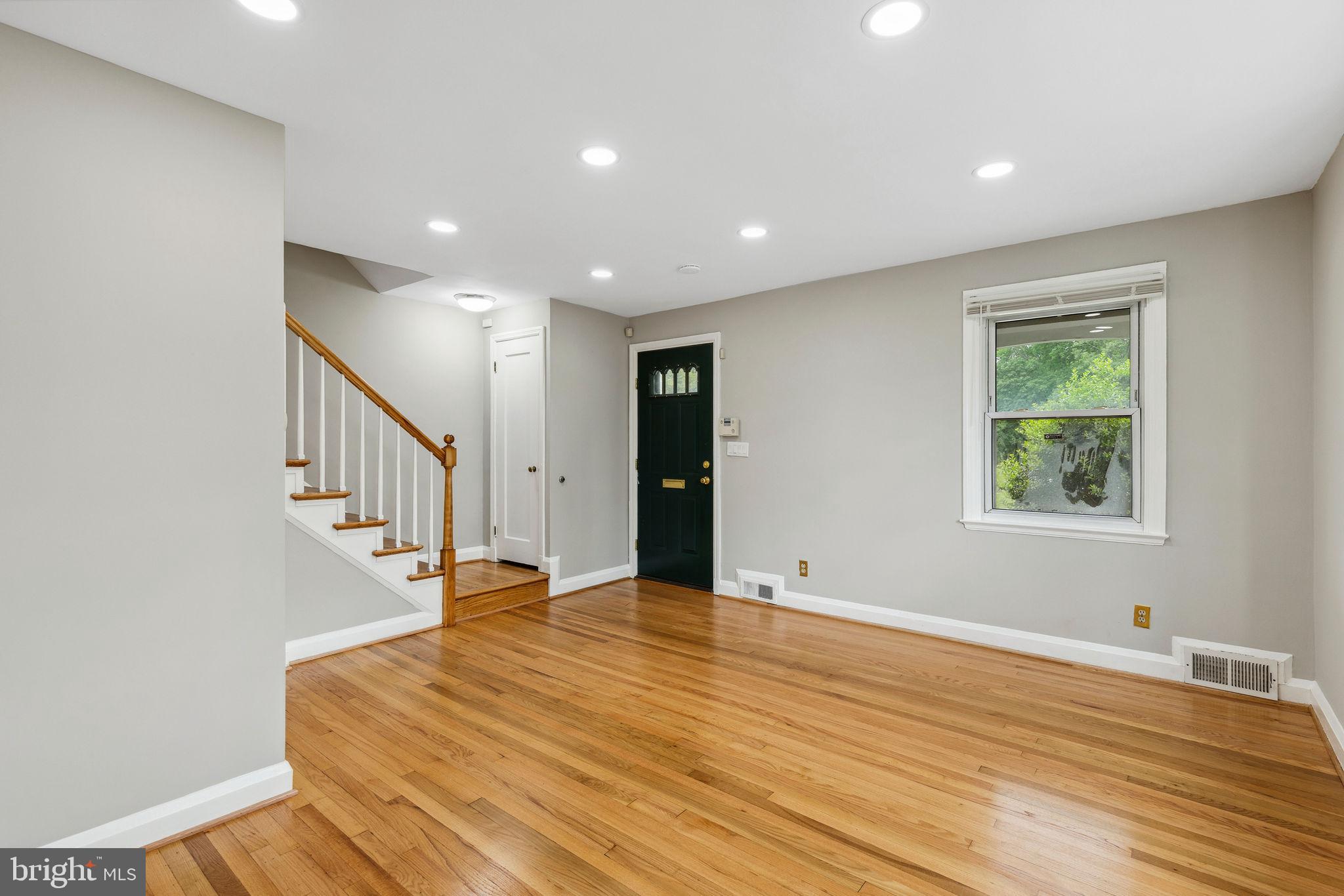 1581 Stonewood Road Baltimore, MD 21239 - Photo 7 of 21 a view of an empty room with wooden floor and a window