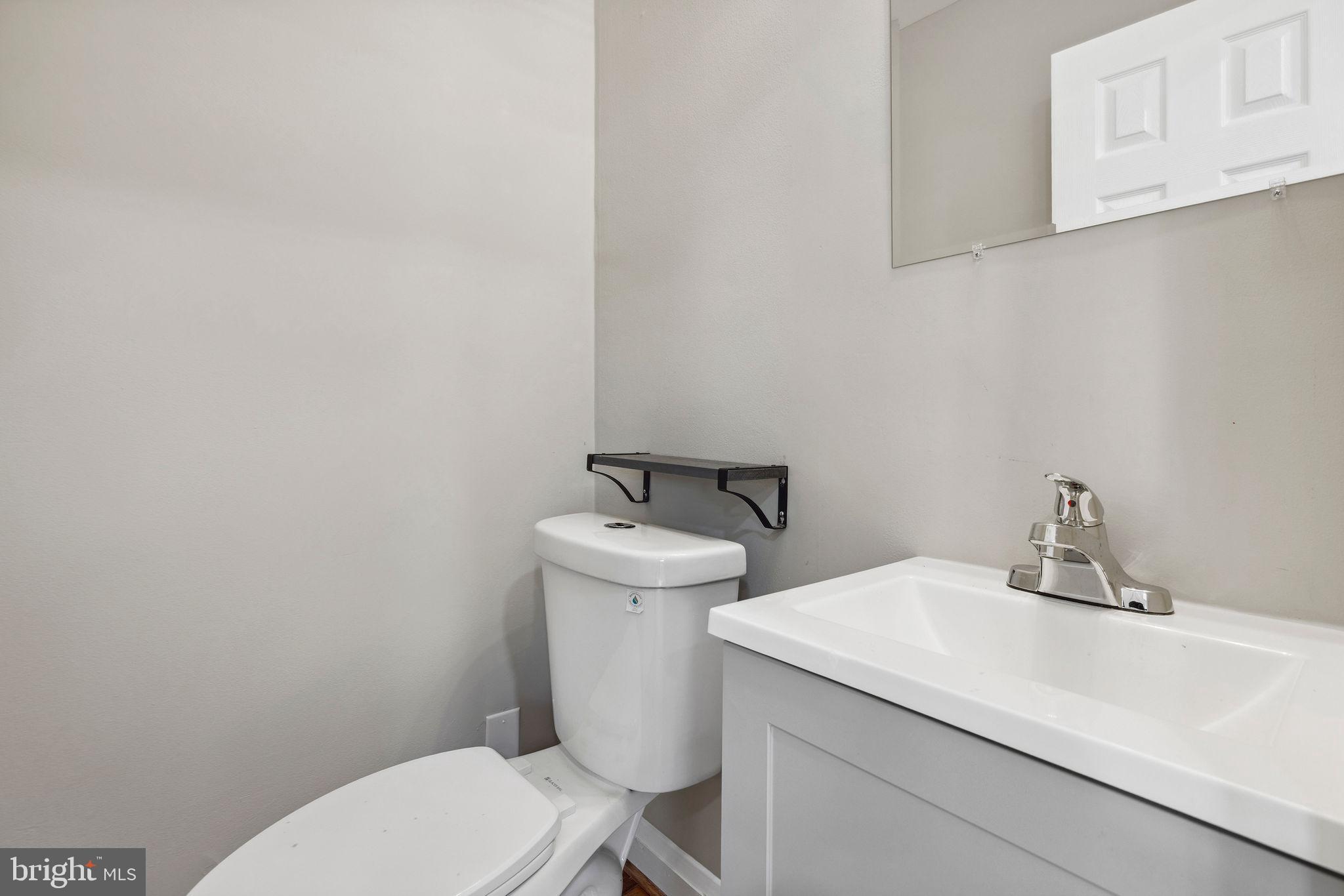 1581 Stonewood Road Baltimore, MD 21239 - Photo 8 of 21 a bathroom with a sink a toilet and mirror