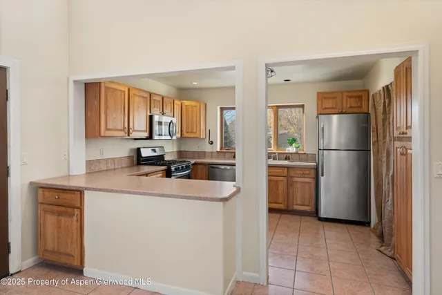 a kitchen with a sink a refrigerator and a stove top oven