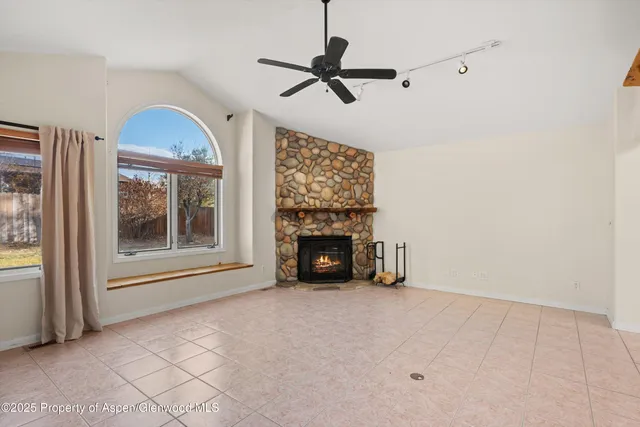 a view of an empty room with a fireplace and a window