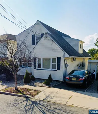 a front view of a house with cars parked