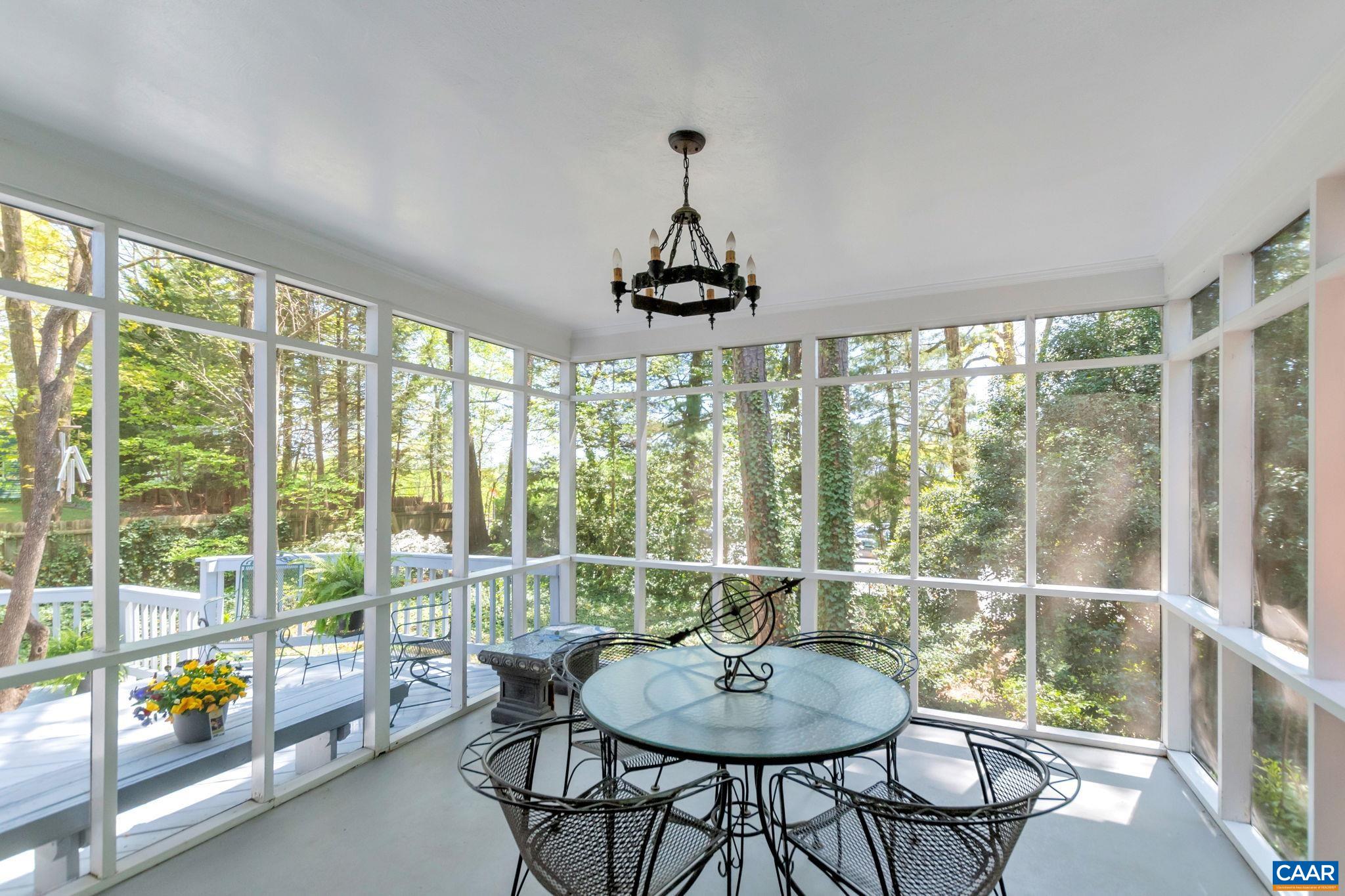 1440 Grove Road Charlottesville, VA 22901 - Photo 26 of 72 a dining room with wooden floor a chandelier a glass table and chairs