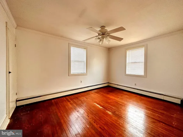 a view of a room with wooden floor and fan