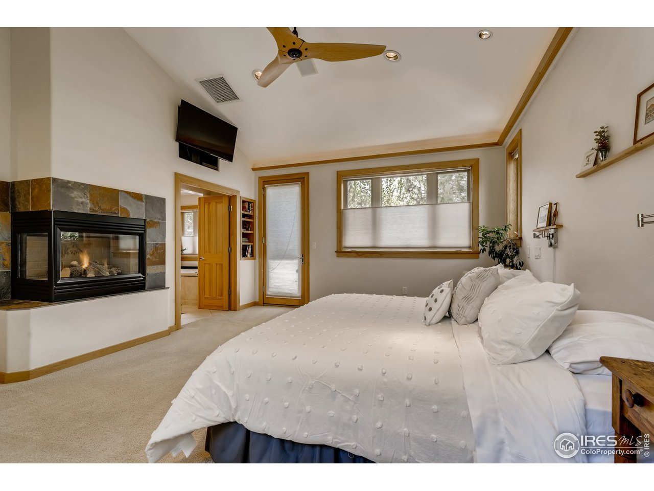 566 Dakota Boulevard Boulder, CO 80304 - Photo 12 of 24 a bedroom with a bed a flat screen tv and dresser