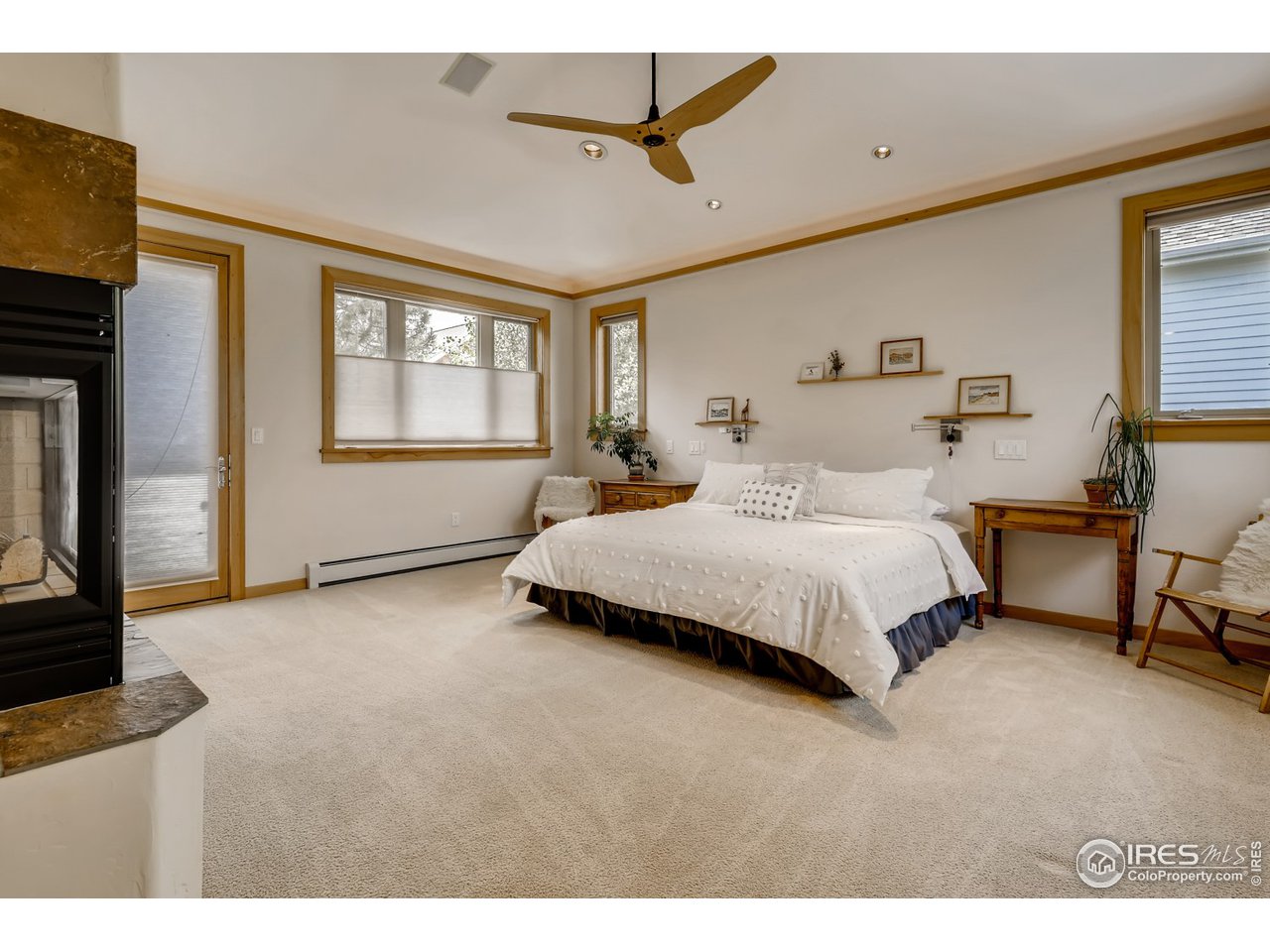566 Dakota Boulevard Boulder, CO 80304 - Photo 13 of 24 a bedroom with a bed a ceiling fan and a fireplace