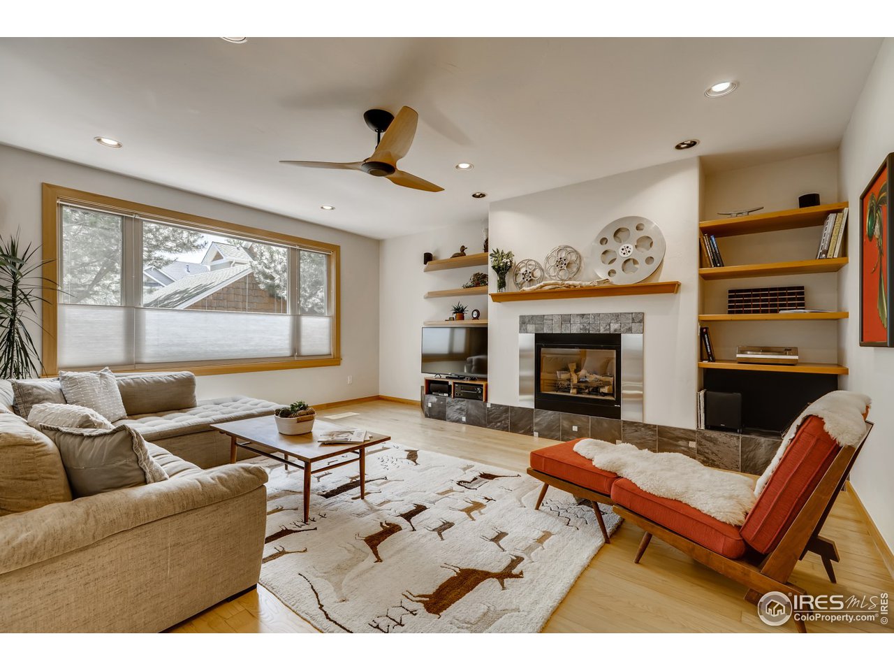 566 Dakota Boulevard Boulder, CO 80304 - Photo 4 of 24 a living room with furniture a fireplace and a flat screen tv