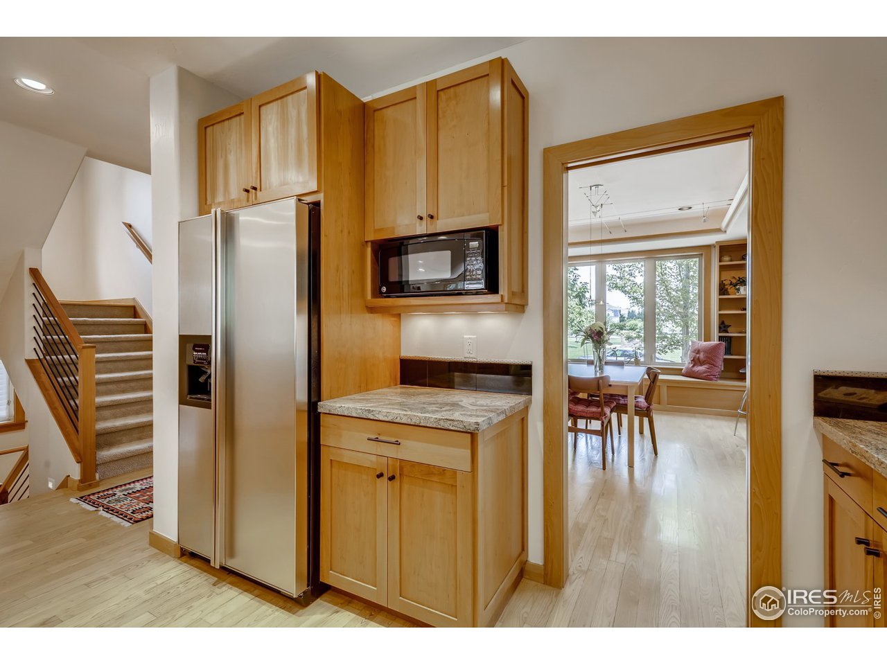 566 Dakota Boulevard Boulder, CO 80304 - Photo 10 of 24 a kitchen with a refrigerator a stove and a dining table with wooden floor