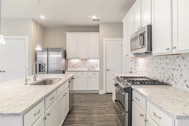 a kitchen with granite countertop a sink stove and cabinets