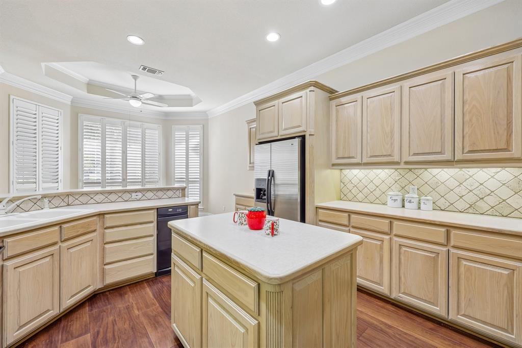 5409 Wedgefield Road Granbury, TX 76049 - Photo 12 of 39 Kitchen featuring wood-finish flooring, light wood cabinetry, white countertops, stainless steel appliances, and a tiled backsplash