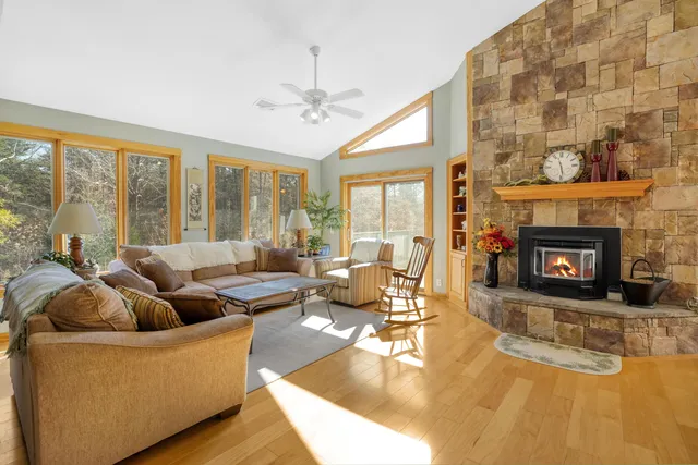 a kitchen with stainless steel appliances granite countertop a refrigerator a stove a sink a dining table and chairs with wooden floor