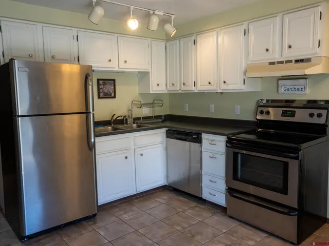 a kitchen with a refrigerator stove and white cabinets