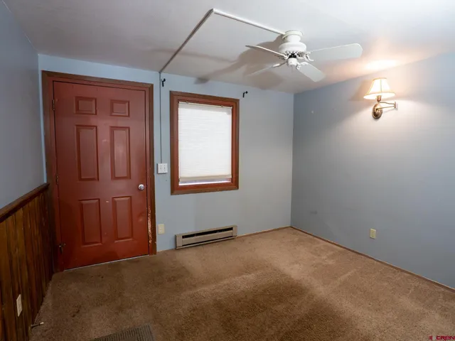 an empty room with windows and fan