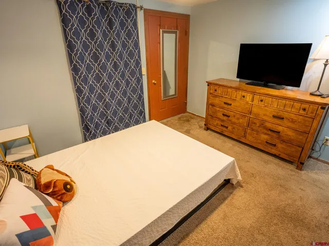 a bedroom with a bed and flat screen tv