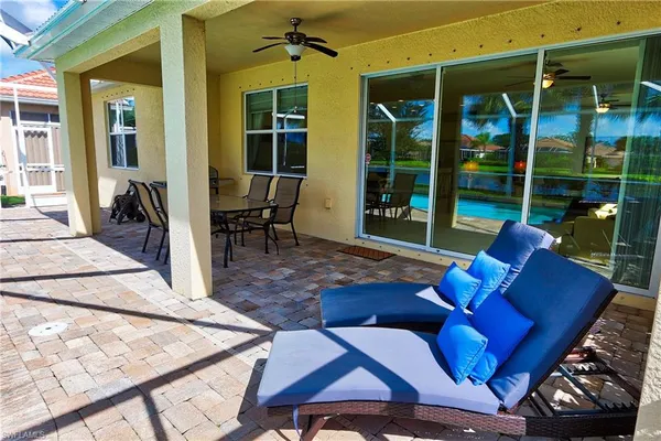 a living room with patio furniture and a floor to ceiling window