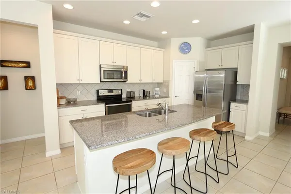 a kitchen with stainless steel appliances granite countertop a stove a sink a refrigerator and a refrigerator