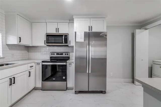 a kitchen with cabinets stainless steel appliances and a counter space