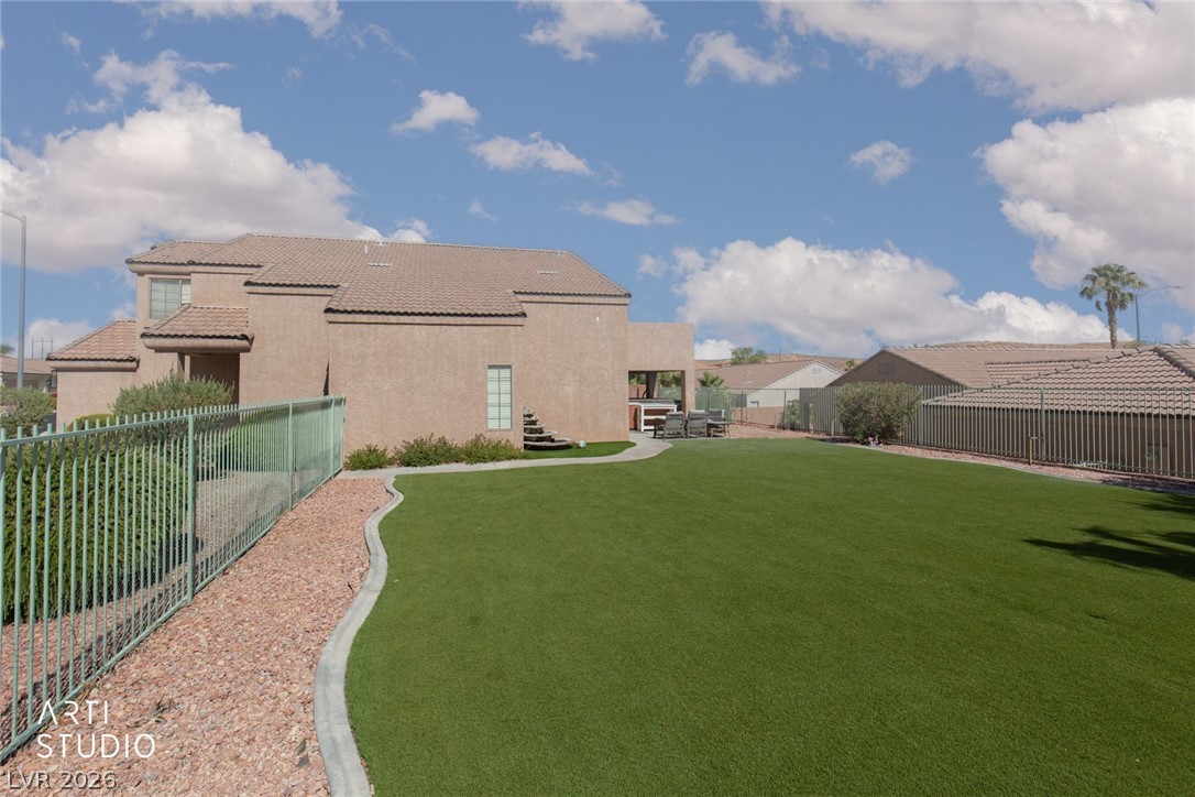 387 Silver Road Mesquite, NV 89027 - Photo 28 of 46 A manicured green lawn borders the stucco exterior under a wide desert sky.