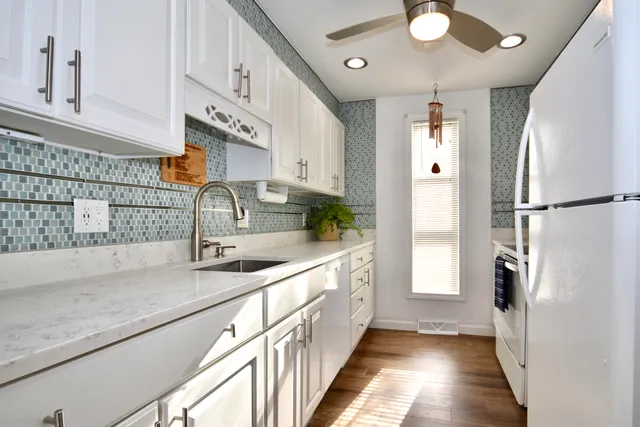 a kitchen with stainless steel appliances granite countertop a sink and a refrigerator