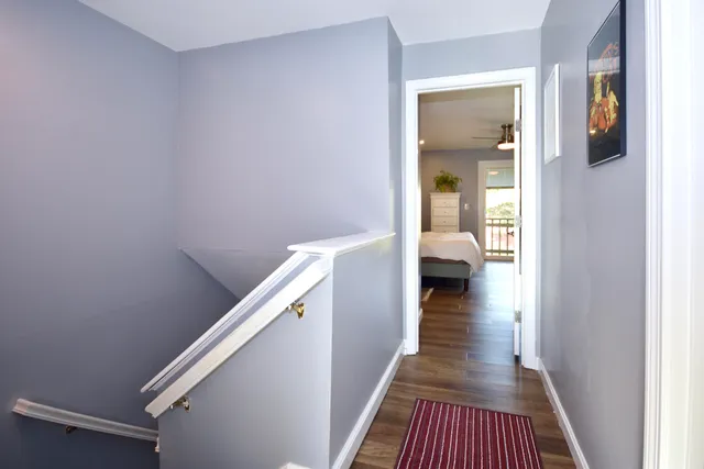 a view of a hallway with wooden floor and stairs