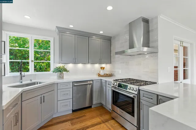a kitchen with cabinets stainless steel appliances a sink and a window