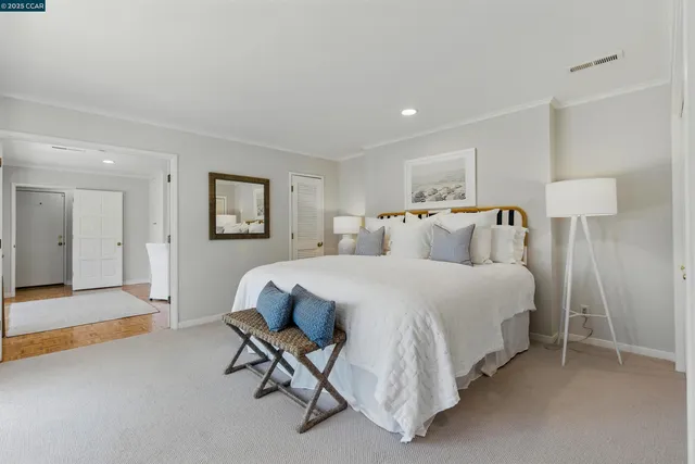 a spacious bedroom with a bed and a cabinets