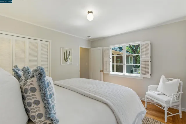 a bedroom with a large bed and a chair with the outer view