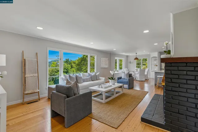 a living room with furniture fireplace and a large window