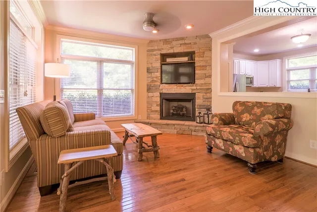 a living room with furniture a large window and a fireplace