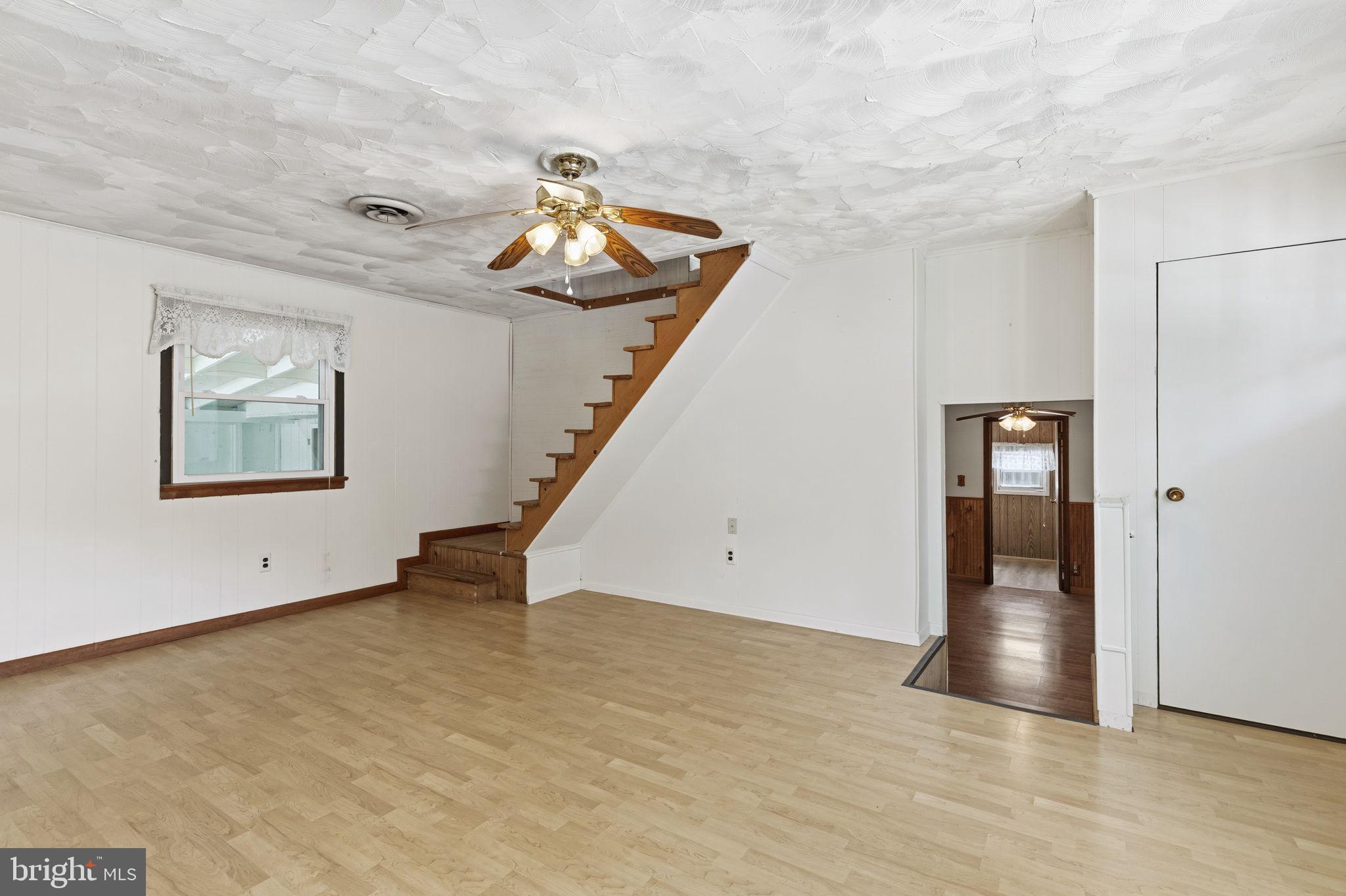 2411 Poplar Road Baltimore, MD 21221 - Photo 6 of 36 a view of an empty room with wooden floor and stairs