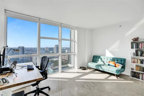 a living room with furniture a rug and a window