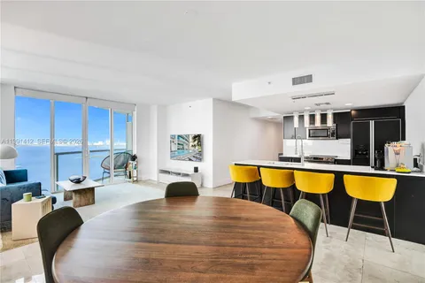 a large white kitchen with a table and chairs