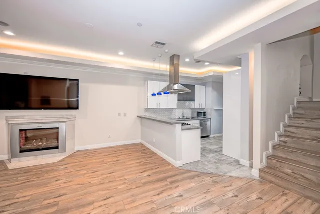 a kitchen with cabinets and wooden floor