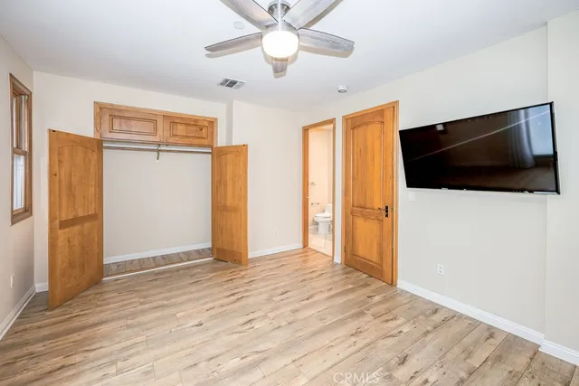a view of a livingroom with wooden floor and a ceiling fan